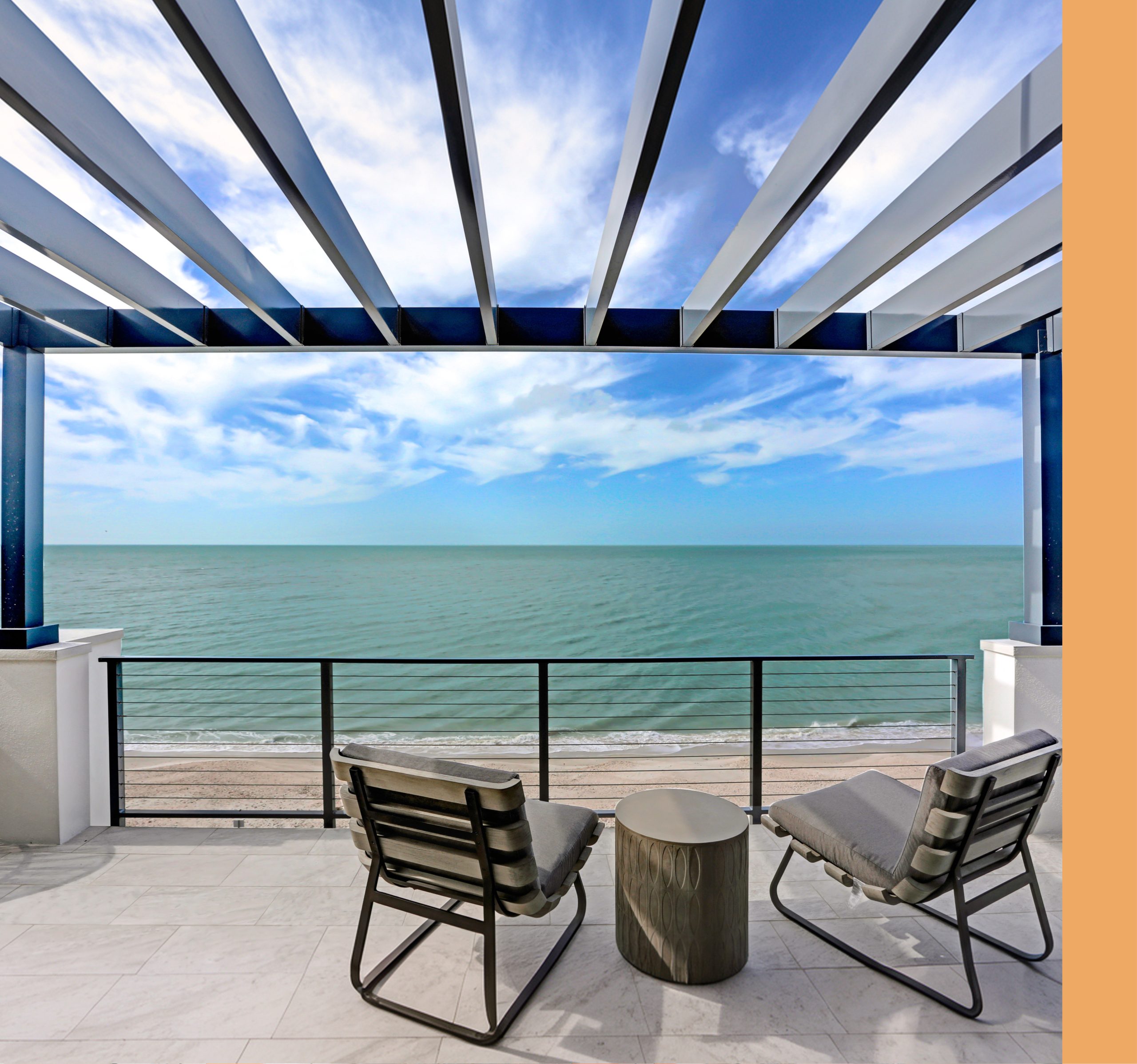 White aluminum lattice patio cover over an oceanfront deck with two lounge chairs facing the Pacific in San Diego